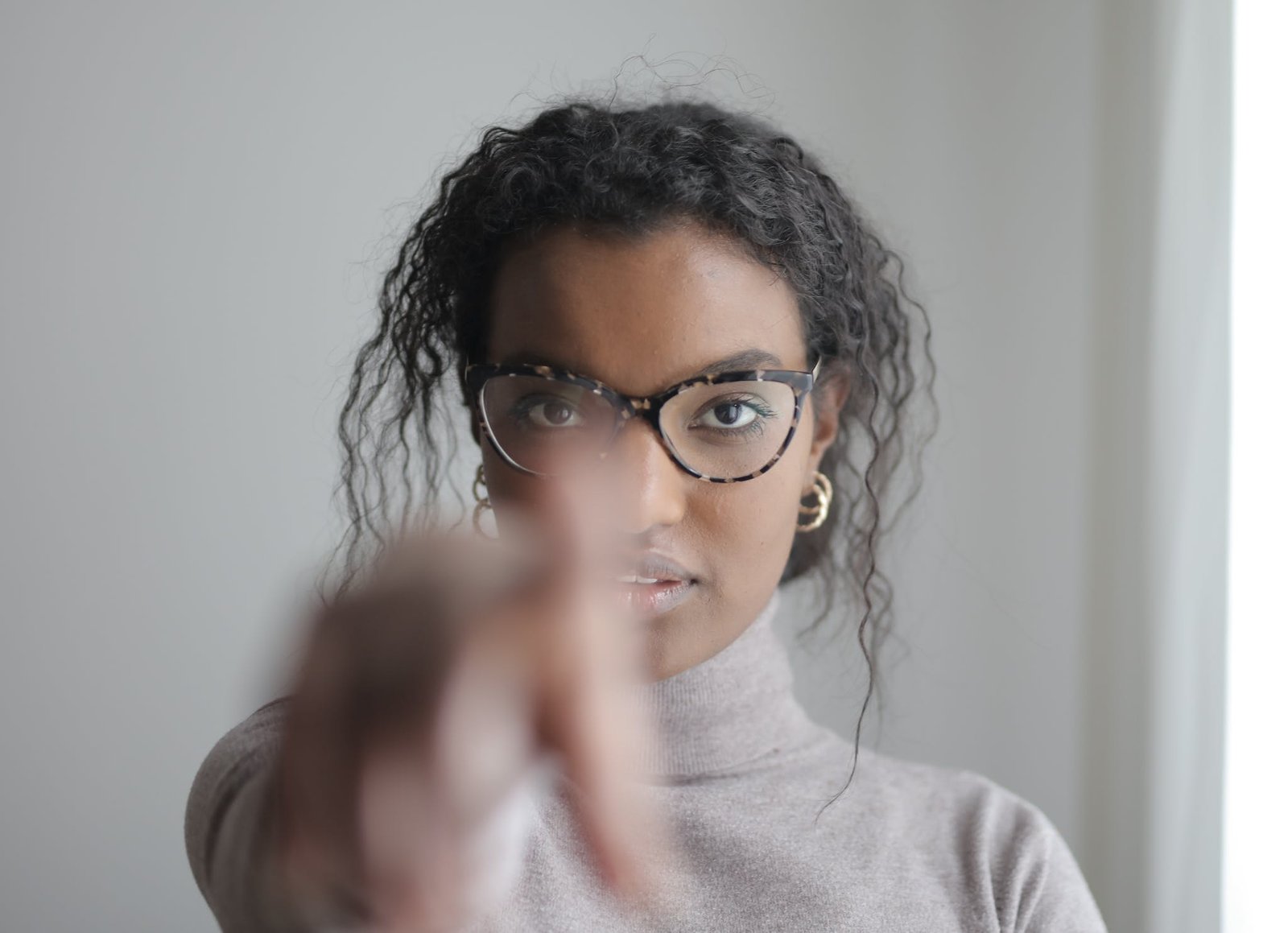 Young ethnic woman pointing at camera